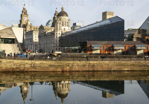 The Three Graces iconic waterfront landmark buildings reflected in water, Canning Dock, Liverpool, England, UK