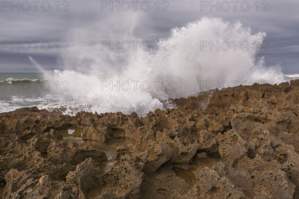 The rocks are scattered throughout the area, with some of them being large and jagged. The water appears to be rough. Rabat, Morocco, Africa
