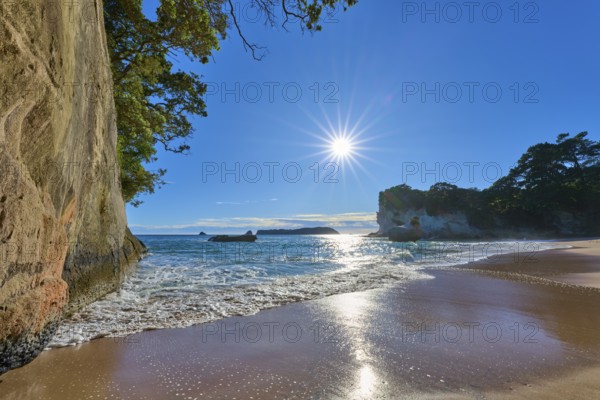 Sunlight on the horizon of a rocky beach, Cathedral Cove, Coromandel, Canterbury, North Island, New Zealand, Oceania