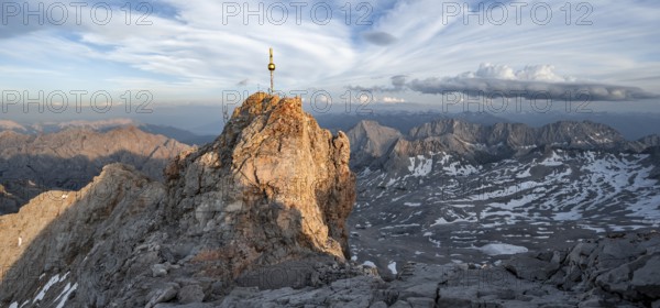 Impressive rocky mountain landscape in the evening light, summit of the Zugspitze with summit cross, steep mountain ridge Jubiläumsgrat and Waxensteinkamm, view into the Höllental, mountain panorama from the Zugspitze, Wetterstein range, Bavaria, Germany, Europe