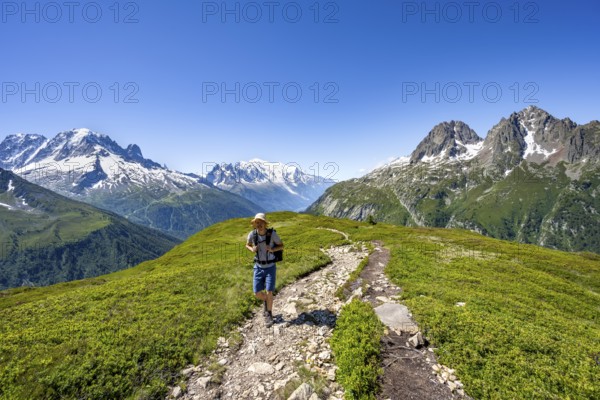 Mountaineer on hiking trail, mountain panorama with glaciated mountain peaks, Aiguille Verte with Aiguille du Midi and Mont Blanc, hike to Aiguillette des Posettes, Chamonix, Haute-Savoie, France, Europe