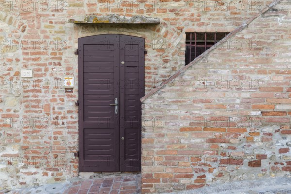 Front door on a house wall, old town centre of Certaldo, Tuscany, Italy, Europe
