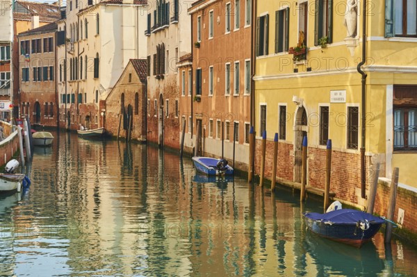 View from 'Casa di otello' over a waterway with boats lying in the water in Venice on a sunny day in winter, Italy, Europe