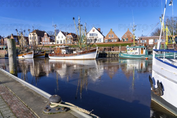 The fishing village of Greetsiel, historic fishing harbour, with the largest shrimp cutter fleet in East Frisia, historic houses, passenger ship Graf Edzard I. Winter, partly frozen, in Lower Saxony, Germany, Europe