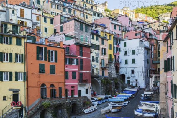 Colourful residential buildings and fishing boats parked in opened space between buildings in Riomaggiore, Cinque Terre, La Spezia, Italy, Europe
