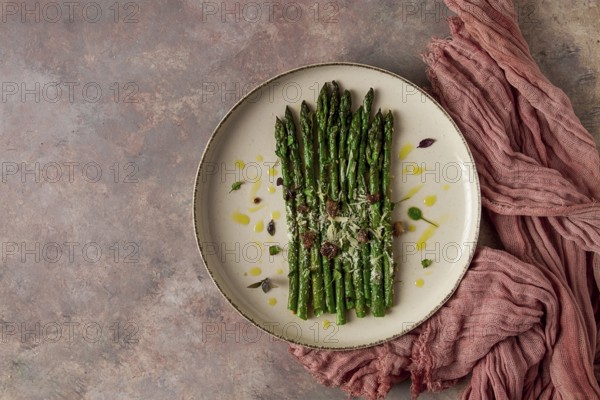Grilled asparagus, spices and herbs, parmesan cheese, on a beige plate, top view, rustic, no people