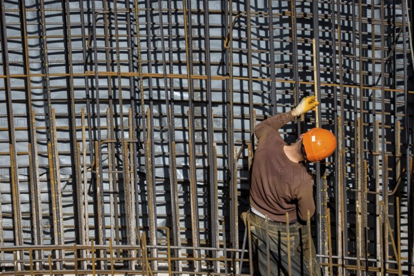 Essen, North Rhine-Westphalia, Germany, construction industry, construction workers working on a building site. Iron binder is a job title for construction workers who bind reinforcing mesh for the reinforcement of concrete parts. The meshes are prepared together with the formwork builder to form moulds, which are then filled with fresh concrete, Europe
