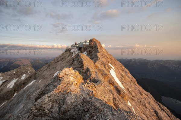 Rocky mountain ridge, summit of the Zugspitze with Zugspitze railway, Jubiläumsgrat, at sunrise, Wetterstein range, Bavaria, Germany, Europe