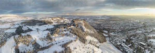 Aerial view, panorama of the snow-covered Hegau volcano Hohentwiel with Germany's largest castle ruins on a cold winter morning, at sunrise, on the right the town of Singen, on the horizon the neighbouring Hegau volcano Hohenkrähen, district of Constance, Baden-Württemberg, Germany, Europe