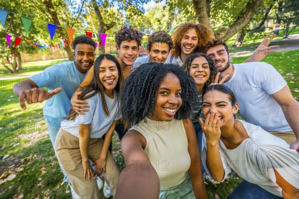 African young woman taking selfie in a park with friends while celebrating a party