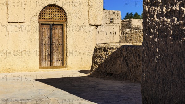 Decorated round arch entrance door in the largest preserved mud town in Oman, Al Bilaad, Al Bilaad Historical Village, Arabian Peninsula, Sultanate of Oman