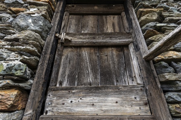 Old wooden door of a typical Ticino stone house in the mountain village of Bordei, Centovalli, Canton Ticino, Switzerland, Europe