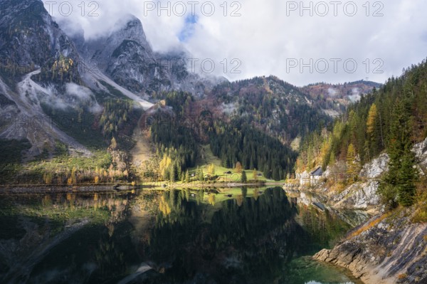 The Vordere Gosausee in autumn. The Gosaukamm on the left. Clouds and sun. Reflection. Vorderer Gosausee, Gosau, Gosau valley, Salzkammergut, Upper Austria, Austria, Europe