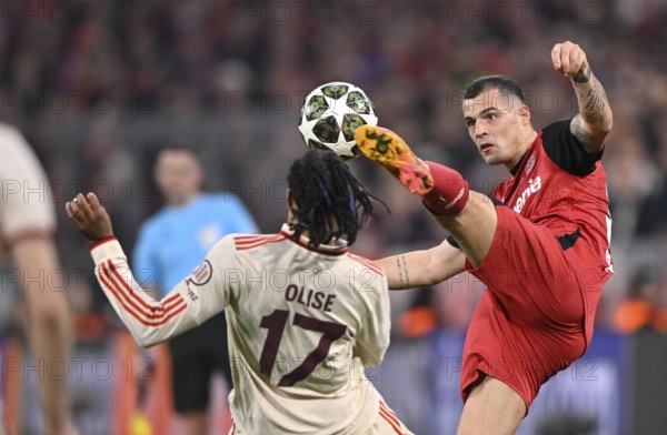 Duel, action Michael Olise FC Bayern Munich FCB (17) v Granit Xhaka Bayer 04 Leverkusen (34) UEFA Champions League Allianz Arena, Munich, Bavaria, Germany, Europe