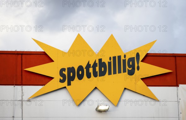 Mülheim, North Rhine-Westphalia, Germany - mock-cheap, lettering on the facade of a speciality store in front of a cloudy sky