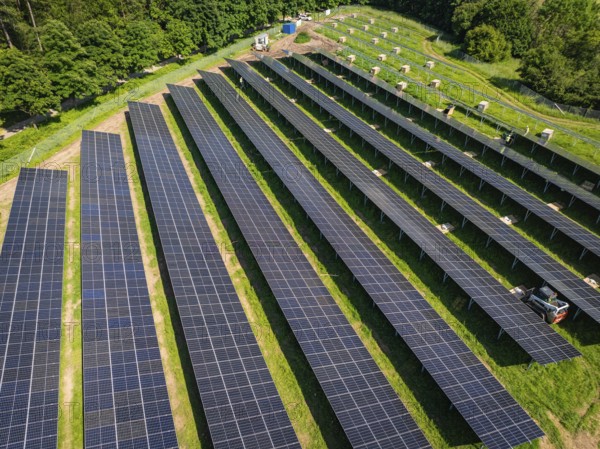 Long rows of solar panels on a green area from an aerial perspective, construction of the Black Forest Nature solar park, Weil der Stadt, Germany, Europe