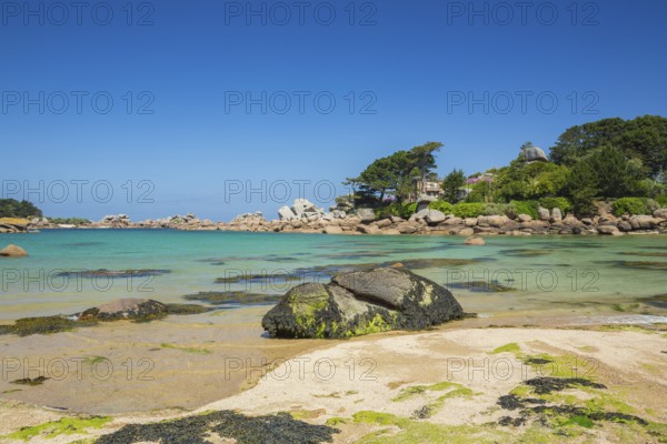 Beach with rocks and sand at the Plage Saint Guirec, with clear blue sky and colors as in the carribians