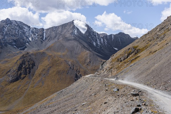 Narrow gravel track in mountain landscape at Chong Ashuu Pass, Tian Shan Mountains, Issyk-Kul, Kyrgyzstan, Asia