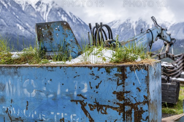 Rusted machine with snow and grass in a mountain landscape, Wald im Pinzgau, Salzburg, Austria, Europe