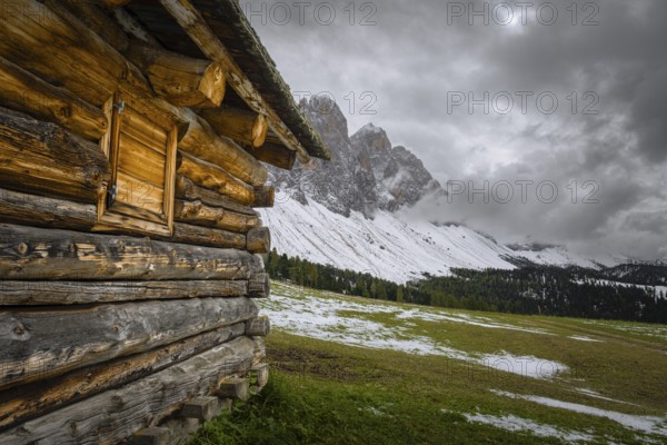 View past a mountain hut to a part of the Geisler Group from the Gampenwiese, Dolomites, snow, Puez-Geisler nature park Park, St. Magdalena, Funes, Villnöss Valley, South Tyrol, Italy, Europe