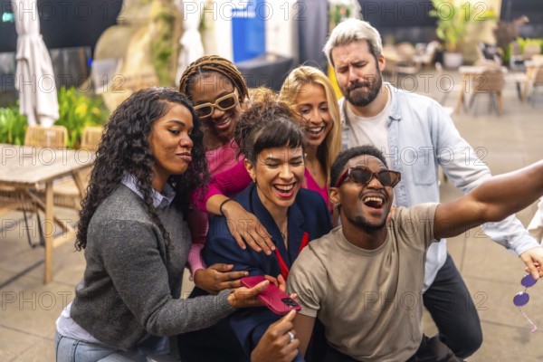 Happy group of multiracial friends taking selfie at night party in the terrace of a bar