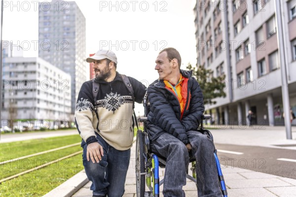 Caregiver assisting a disabled man in a wheelchair, enjoying a city stroll while engaging in friendly conversation and support