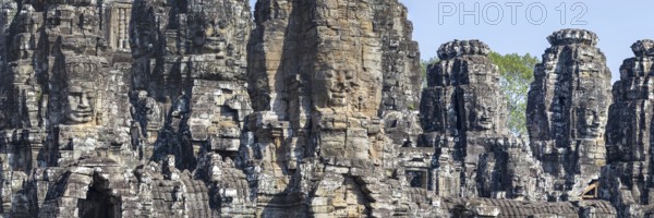 Panoramic image of giant stone-carved faces of the Bodhisattva Lokeshvara, also known as Avalokiteshvara, Bayon Temple, Angkor Thom, UNESCO World Heritage Site, Angkor Wat, Siem Reap, Cambodia, Asia