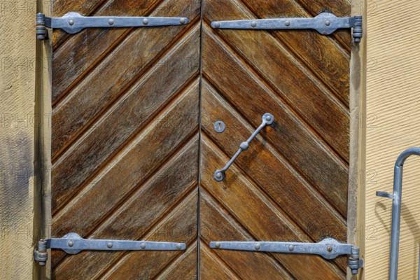 Detail of a historic iron-framed wooden door in the outer wall of the Old Palace in Stuttgart, Baden-Württemberg, Germany, Europe