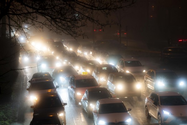 Dense fog, with visibility sometimes less than 100 metres, city centre traffic during rush hour at Haumannplatz, tributary to the B224, in Essen, North Rhine-Westphalia, Germany, Europe