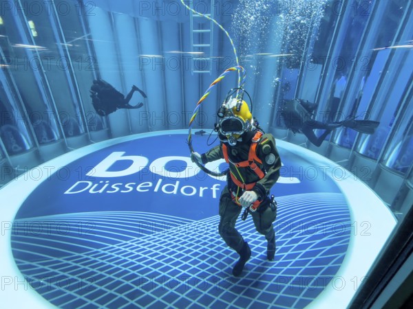 Diver helmet diver from the German Navy with hose for air supply from outside the water during presentation in diving tower at the boot Düsseldorf trade fair, in the background scuba diver, on the ground logo and lettering of Messe boot, Düsseldorf, North Rhine-Westphalia, Germany, Europe