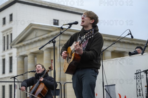 Marlo Grosshardt plays at the Fridays for Future climate strike at the Brandenburg Tor in Berlin. Bottom left Rahel Meiller with cello. 14.02.2025