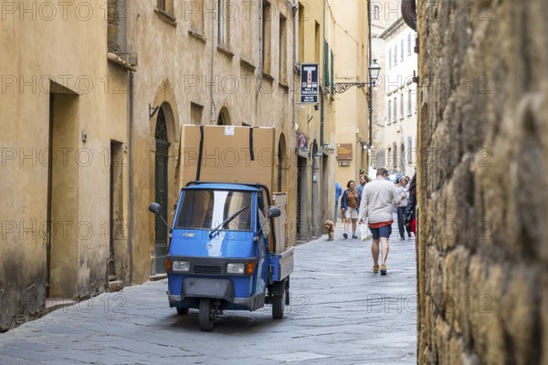 Three-wheeled Piaggio Ape van packed full in an alleyway in the historic centre of Volterra, province of Pisa, Tuscany, Italy, Europe