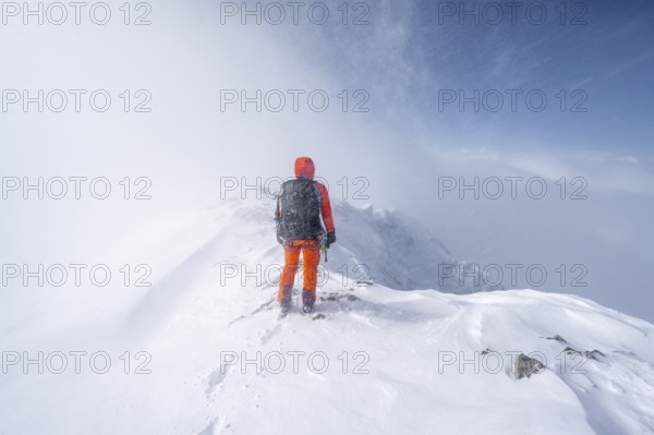 Ski tourer in snowy mountain landscape, at the summit of the Wildhorn, cloudy mood, high tour, Bernese Alps, Bernese Oberland, Switzerland, Europe