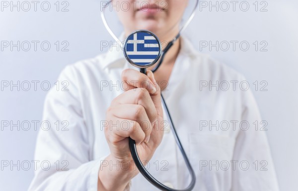 Doctor holding stethoscope with Greece flag. National Health System of Greece