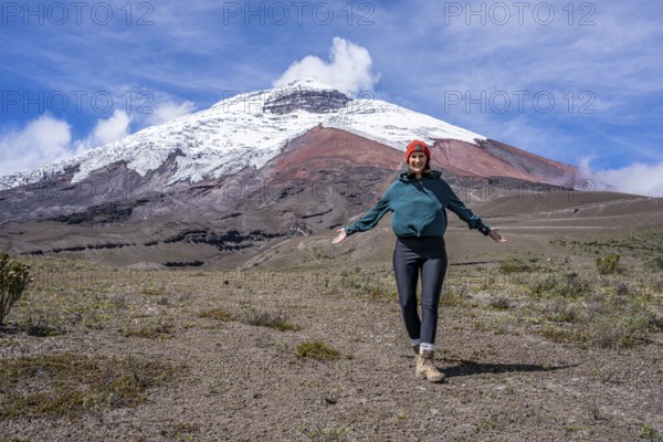 Women poses in front of the Cotopaxi volcano, Cotopaxi, Cotopaxi National Park, Latacunga, Ecuador, South America