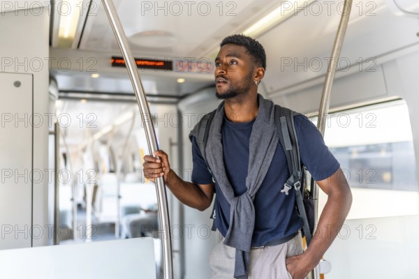 Cheerful and confident african young man travelling by metro along the city