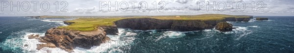 Extensive coastline with dramatic cliffs and a vast, cloudy sky over the sea, Kilkee