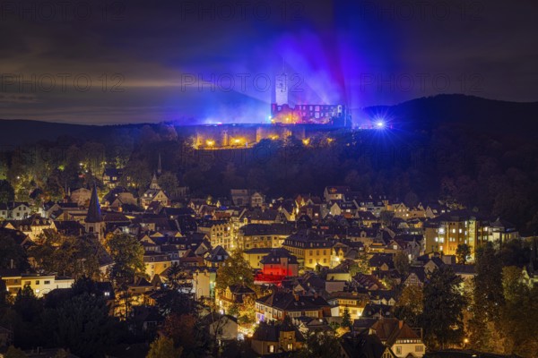 The castle in the town of Königstein im Taunus is brightly illuminated in the evening. From 18 October to 3 November 2024, the castle ruins will host the Frankenstein Halloween Festival under the motto A new Chapter of Fear, Taunus, Königstein, Hesse, Germany, Europe