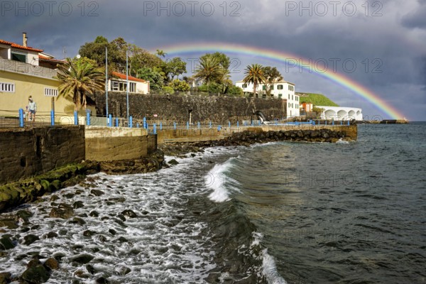 Promenade in rainy weather with rainbow on the beach of the Atlantic Ocean, municipality of Santa Cruz, Madeira, Portugal, Europe