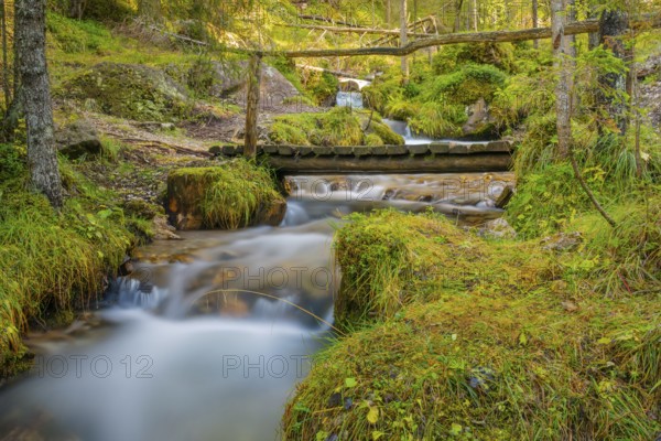 View of a wooden bridge leading over a torrent, long exposure, Dolomites, Puez-Geisler nature park Park, St. Magdalena, Funes, Villnößtal, South Tyrol, Italy, Europe