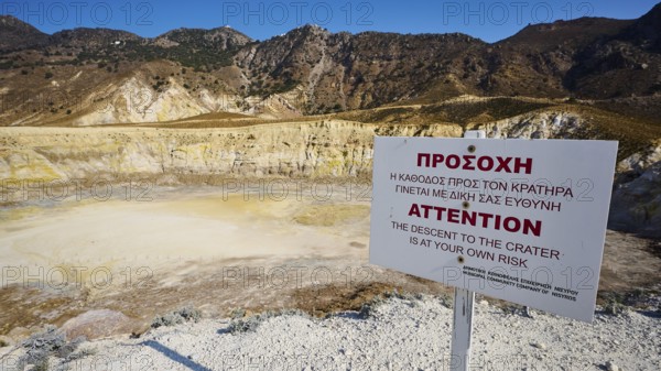 Warning sign in front of volcanic crater in sunny mountainous landscape, volcanism, volcanic island, Caldera Stefanos, Nisyros, Dodecanese, Greek Islands, Greece, Europe
