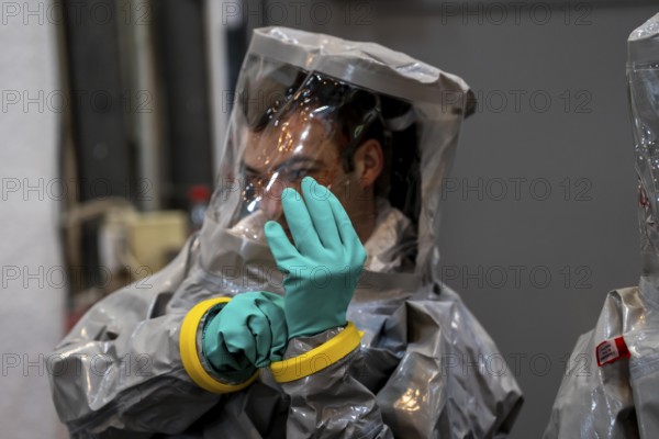 Decontamination of injured persons after an assumed accident involving hazardous substances, fire brigade and aid organisations practise setting up and operating a decontamination station, injured persons are sighted and then washed in a special shower tent to remove possible hazardous substances and chemicals in order to avoid further injuries, the emergency services wear special, ventilated protective suits, large-scale exercise by the Essen fire brigade
