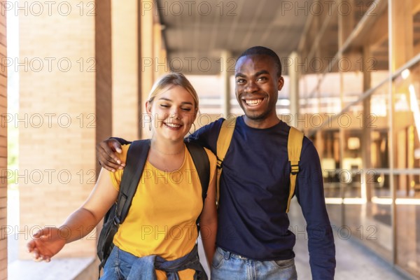 Multi-ethnic caucasian and african friends embracing from shoulder walking along the university