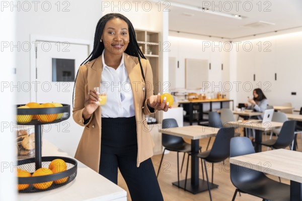 Businesswoman enjoying a healthy breakfast with orange juice and fruits in a hotel restaurant during her business trip