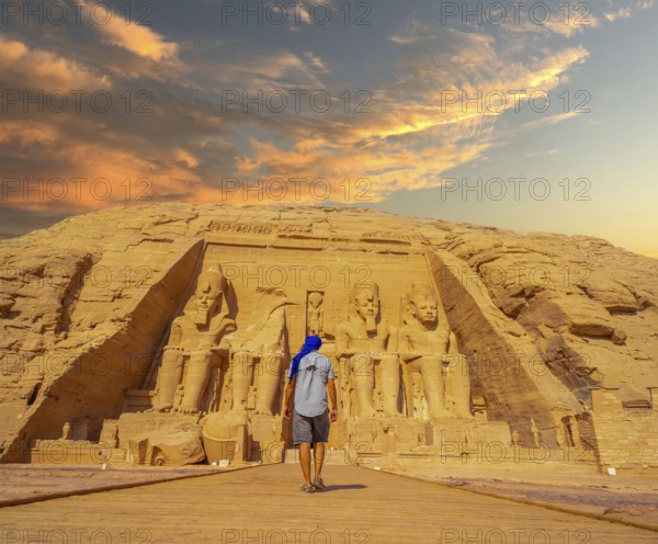 A young man walking towards the Abu Simbel Temple in southern Egypt in Nubia next to Lake Nasser. Temple of Pharaoh Ramses II, travel lifestyle