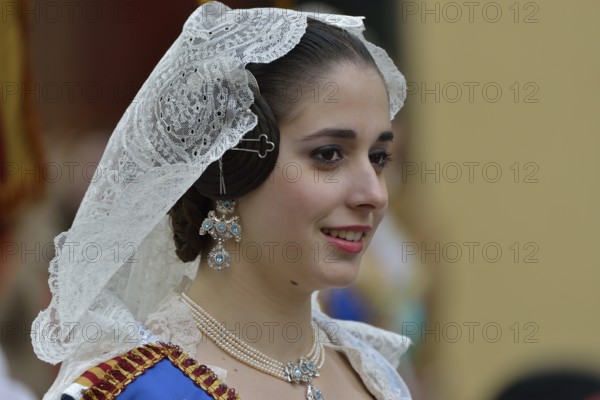Fallas festival, woman in a traditional costume during the parade in the Plaza de la Virgen de los Desamparados, Valencia, Spain, Europe