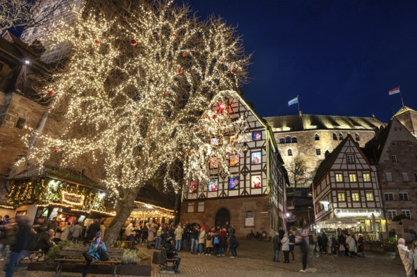 Tiergärtnertorplatz with the Pilatushaus, built in 1489, a historic town house with an Advent calendar on 18 December 2024 at dusk, behind the Kaiserburg, Nuremberg, Middle Franconia, Bavaria, Germany, Europe