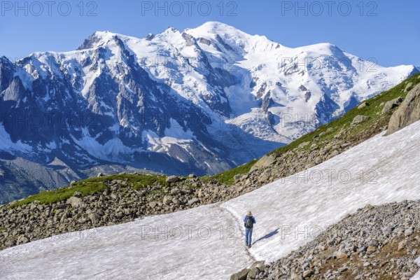 Mountaineer crossing a snowfield, view of spectacular glaciated peaks of Mont Blanc, Mont Blanc massif, Aiguilles Rouges, Chamonix-Mont-Blanc, Haute-Savoie, France, Europe