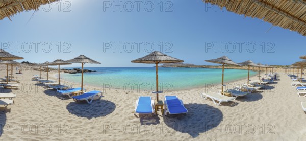 Diakoftis sandy beach with sun loungers and parasols, surrounded by clear, turquoise-coloured sea, Diakoftis beach, Karpathos, Greece, Europe