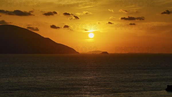 Sunset over the sea with sunbeams and an island on the horizon, warm yellow tones dominate, sunset, Kassos, Karpathos, offshore islands, Dodecanese, Greek Islands, Greece, Europe